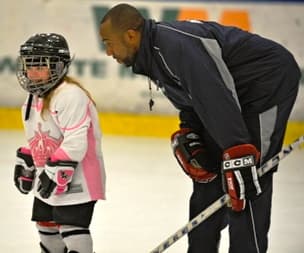 Brad Perry coaching a young player on the ice